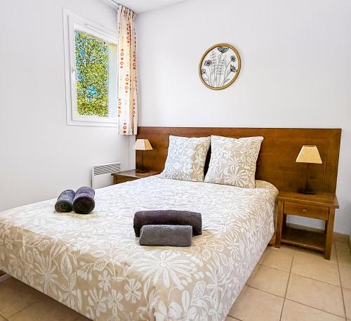 a bedroom with a large bed with two pillows at Élégant T3 avec terrasse & piscine et parking in Prayssac