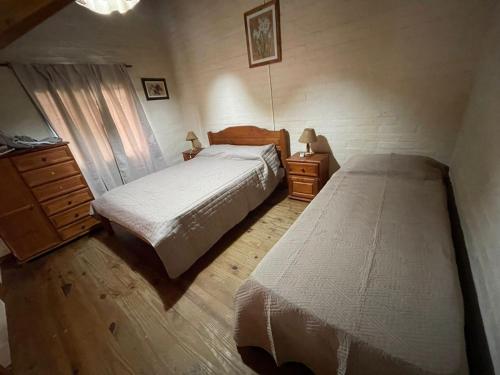 a bedroom with two beds and a dresser at Cabañas Del Sol in Trapiche