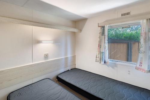 a small room with a bed and a window at Mobilehome chez dede in Porto-Vecchio