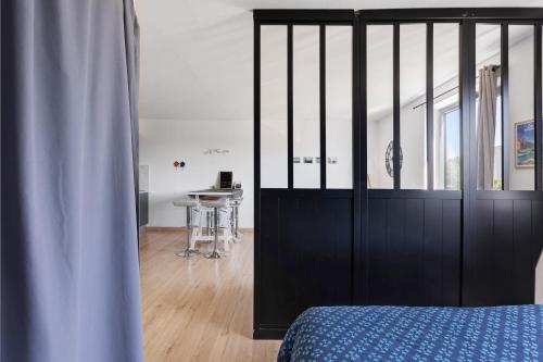 a bedroom with a black bed and a table at Le Cabano'scope in Chasseneuil-du-Poitou