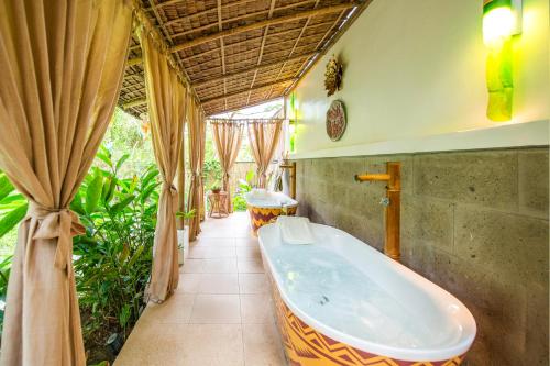 a bathroom with a bath tub in a room at Nawa Wellness in Calatagan