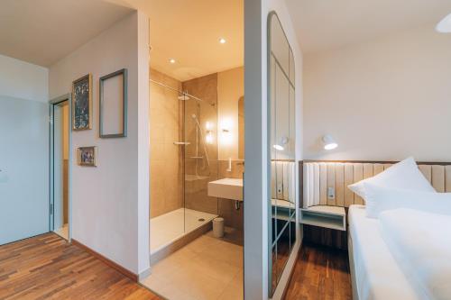 a bedroom with a shower and a bed and a bathroom at Hotel Amalia - Boutique Hotel in Landshut