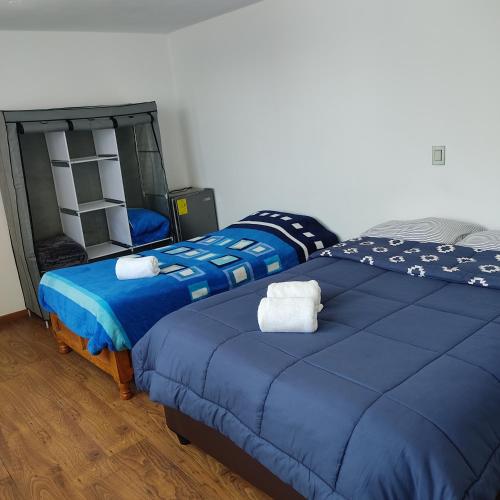 two beds sitting next to each other in a bedroom at Suites Casa Blanca Metepec in Toluca