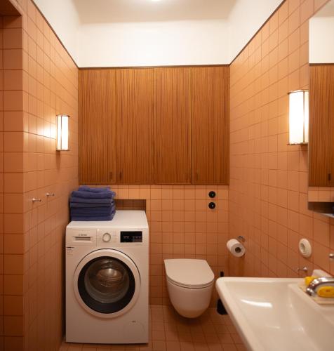 a bathroom with a washing machine and a toilet at The Residence in Oslo
