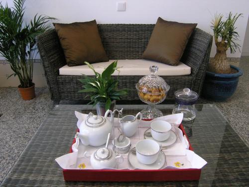 a coffee table with tea cups and saucers on a couch at Casa de Alpajares - Guest House & Spa in Freixo de Espada à Cinta