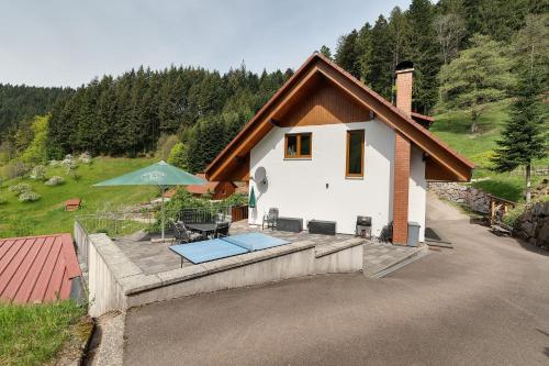 a small white house with a table and a patio at Holderstanzenhof in Bad Griesbach
