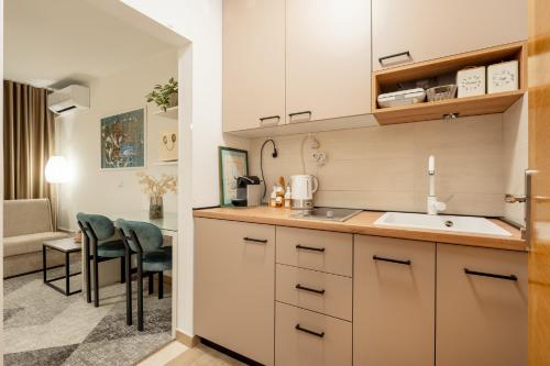a kitchen with a sink and a living room at Apartmani IVA in Neum