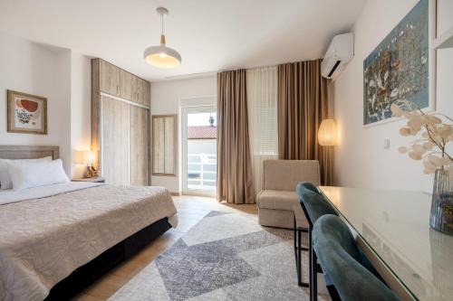 a bedroom with a bed and a desk and a chair at Apartmani IVA in Neum
