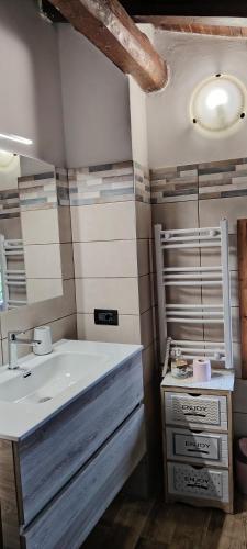 a bathroom with a white sink and a mirror at La Casetta 23 in Perledo