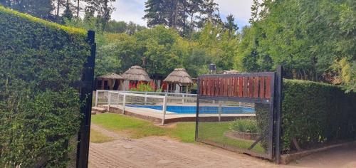 a gate leading to a swimming pool with a fence at Cabañas Del Sol in Trapiche