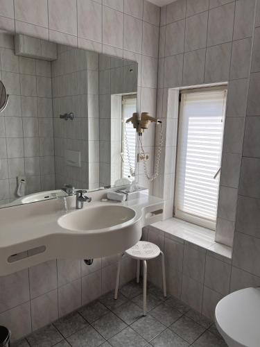 a bathroom with a sink and a tub and a mirror at Parkhotel Krone Maleck in Emmendingen