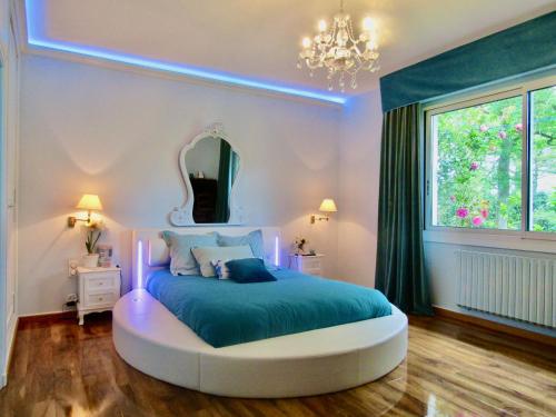 a bedroom with a large bed with a blue ledvisor at La Clotière in La Guerche-de-Bretagne