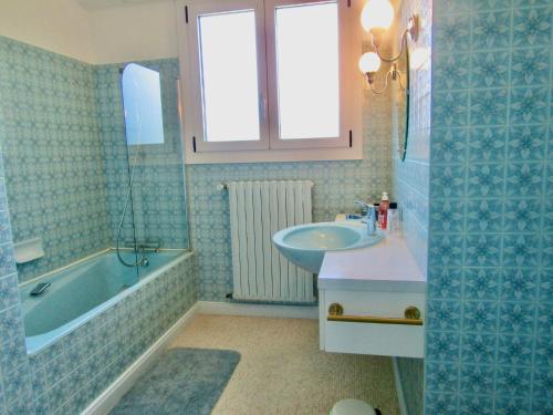 a bathroom with a tub and a sink and a bath tub at La Clotière in La Guerche-de-Bretagne