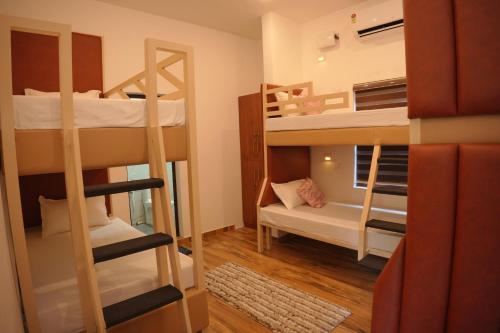 a dorm room with bunk beds and a couch at Dune Hostel - Dune Homestay in Alleppey