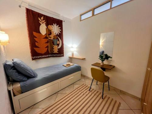 a small bedroom with a bed and a chair at Évasion azuréenne - balcon, confort à Nice in Nice
