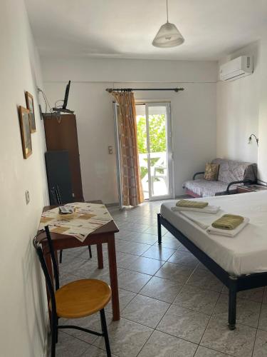a bedroom with a bed and a table with a chair at studios costareli in Vrachonisída Diapóri
