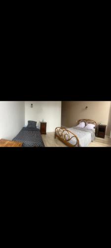 two pictures of a bedroom with two beds at Hôtel Restaurant Le Vieux Logis in Aignan