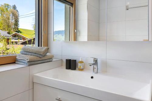 a white bathroom with a sink and a mirror at Försterhaus Wohnung Obergeschoss in Egg