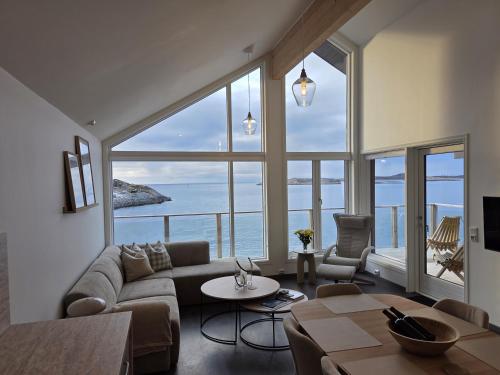 a living room with a couch and a large window at Hamn i Senja - Private top apartment with seaview in Senja