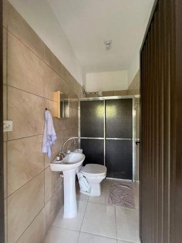 a bathroom with a white toilet and a sink at Rancho Rocha in Buritama