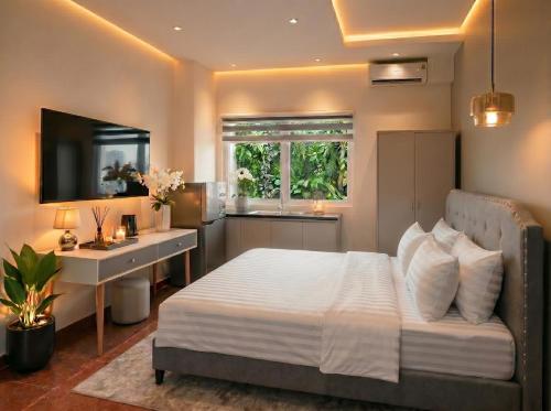 a bedroom with a bed and a desk and a window at Soléa Boutique Hotel & Spa By Sol in Ho Chi Minh City