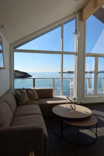a living room with a couch and a large window at Hamn i Senja - Private top apartment with seaview in Senja