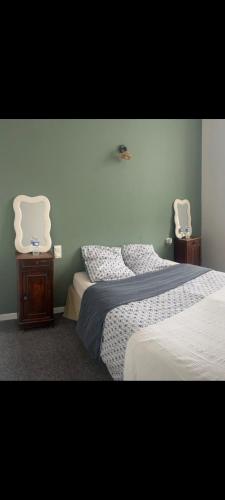 a bedroom with two beds and two white chairs at Hôtel Restaurant Le Vieux Logis in Aignan