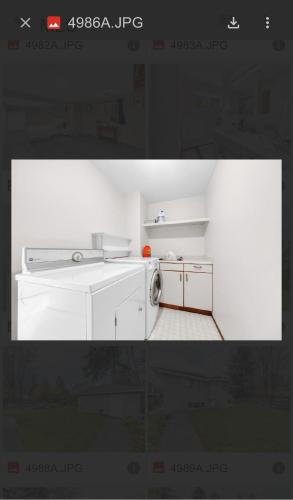 a picture of a white kitchen with a washing machine at Spacious house 6 bedroom near ferry in Delta