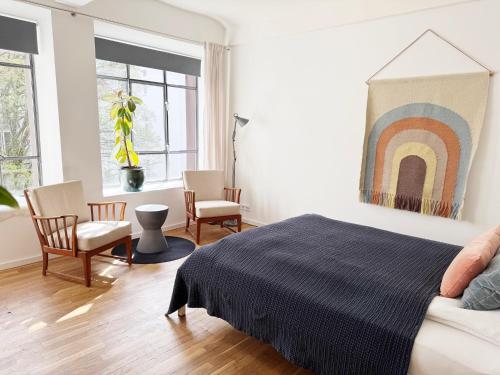 a bedroom with a bed and a rainbow painting on the wall at Seven Rooms Hamburg in Hamburg