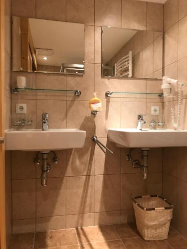 a bathroom with two sinks and a mirror at Hüttenzeit almhütte sölden in Sölden