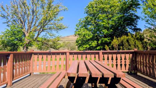 a wooden bench sitting next to a wooden fence at Lunalodge in Trawsfynydd