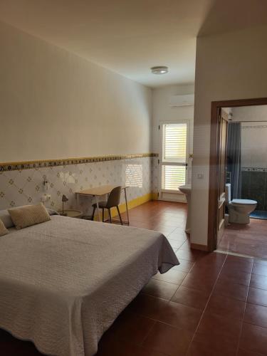a bedroom with a bed and a bathroom with a toilet at Casa Santa Úrsula in Casinos