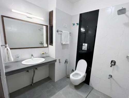 a white bathroom with a sink and a toilet at Rajvin Heavens Resort in Bhīm Tāl