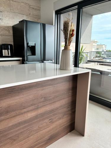 a kitchen with a counter with a vase of flowers on it at Penthouse Jacuzzi SeaView Suite in Makarska