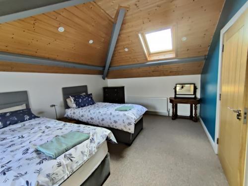 a bedroom with two beds and a wooden ceiling at 50-5 Coolyvenny in Killure