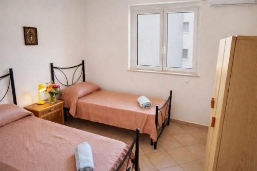 a room with two beds and a window at HOUSE IN PARADISE - Realmonte with Free parking in Realmonte