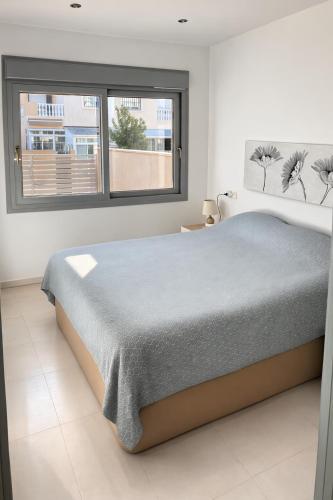 a bedroom with a large bed and a window at Casa Laguna Torrevieja in Torrevieja