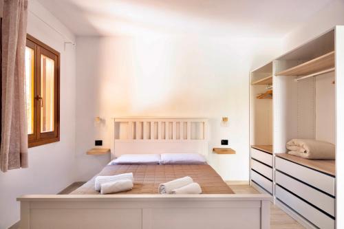 a bedroom with a bed with white walls at Zenia Rooms in San Teodoro