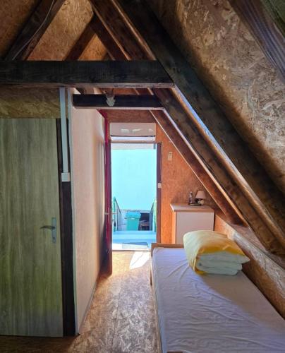a bedroom with a bed in a attic with a window at Alfa in Kulen Vakuf