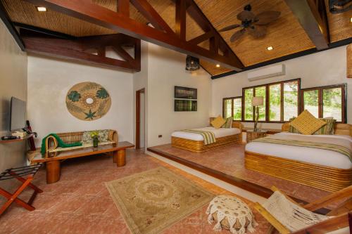 a bedroom with two beds and a ceiling at Nawa Wellness in Calatagan