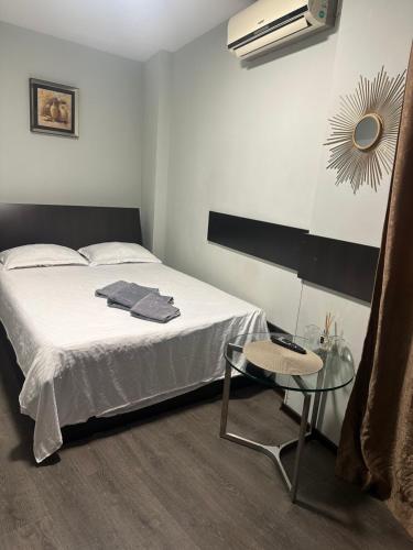 a white bedroom with a bed and a table at A G Studio's Palas-Iasi 2 in Iaşi