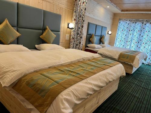 a hotel room with two beds and a window at Kashmir cottage in Pahalgām