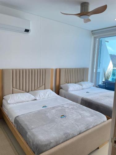 two beds in a bedroom with a window at 18 El escape perfecto frente al mar in Santa Marta