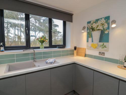 a kitchen with a sink and two windows at Harvest Cottage 2 in Berwick-Upon-Tweed