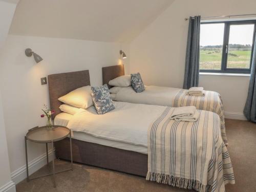 a bedroom with a bed with a table and a window at Harvest Cottage 2 in Berwick-Upon-Tweed