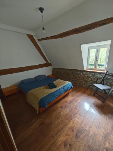 a bedroom with a bed and a chair in a attic at La Belangerie in Saint-Loup