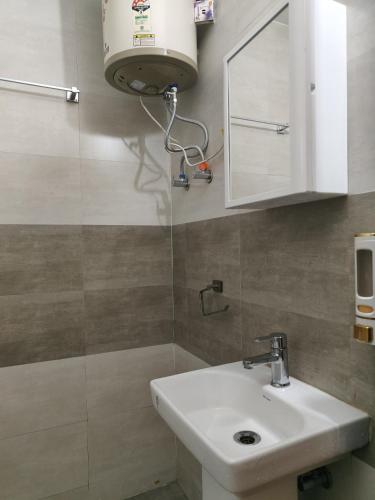 a bathroom with a white sink and a mirror at LivShared in Patna