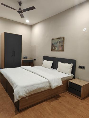 a bedroom with a large bed and a ceiling fan at LivShared in Patna