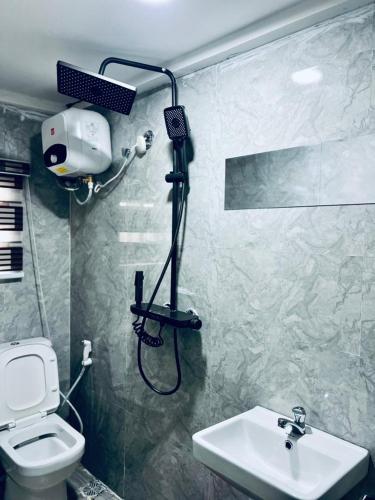 a bathroom with a shower and a toilet and a sink at TFE Apartments in Ibadan