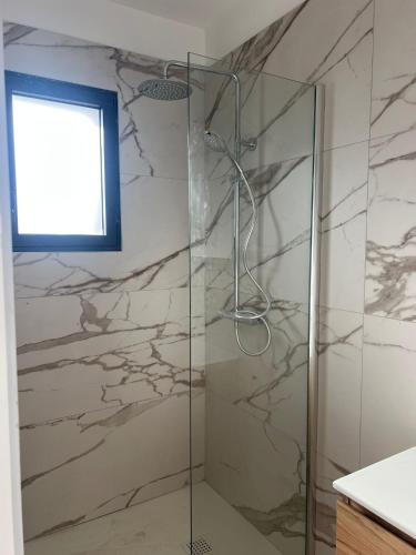 a shower with a glass door in a bathroom at Villas Vangarone in Lecci
